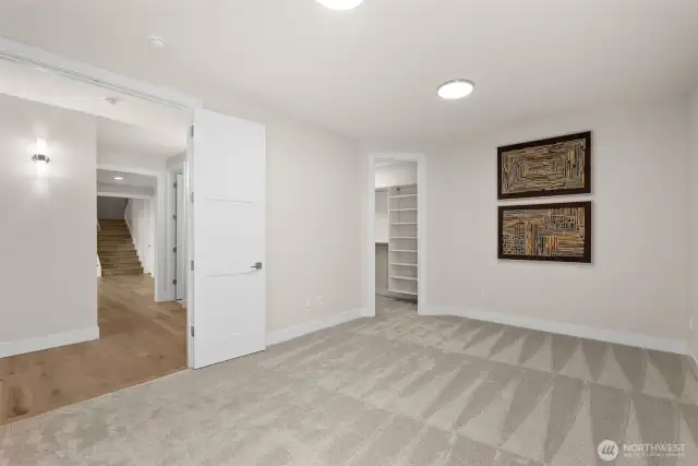 Another downstairs bedroom with a spacious walk-in closet, showcasing the unparalleled functionality of this home’s thoughtfully designed floor plan.