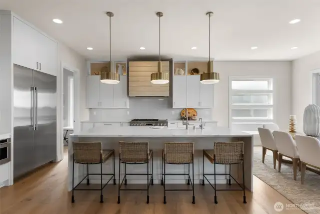 Outfitted with Bellmont cabinetry, premium appliances, and elegant waterfall-edge quartz countertops, this kitchen is truly top of the line—designed to impress and perfectly suited for entertaining.