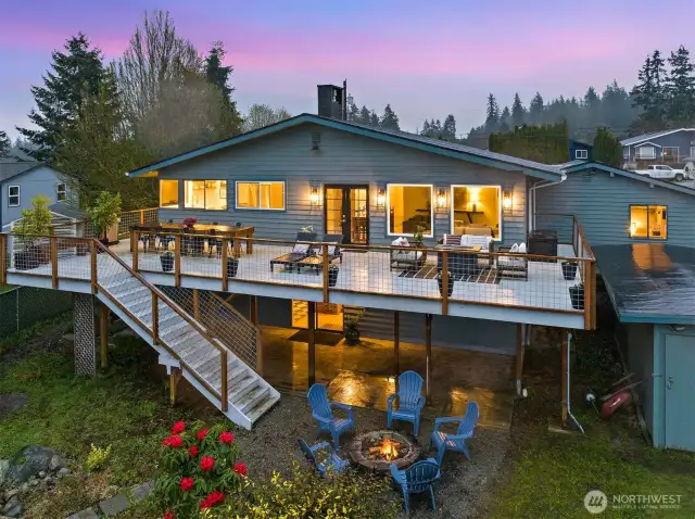 Rear view of giant deck perfect for entertaining! daylight basement and bonus room behind garage really highlight the size of the house that isn't as obvious from the front.