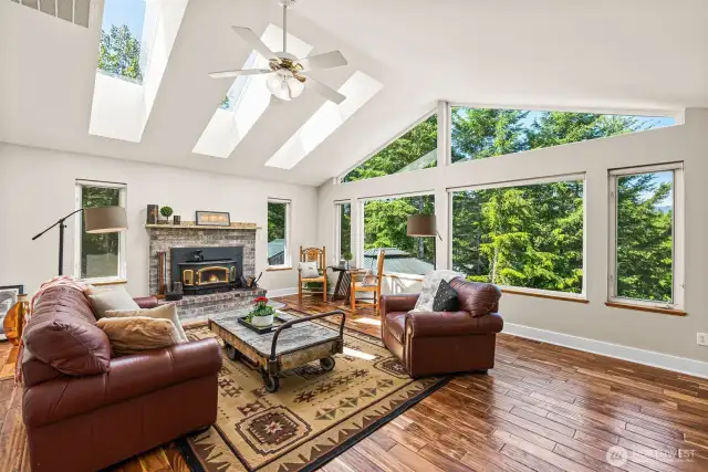 Living room with so much natural light and stunning views. Cozy fireplace that has been inspected yearly, natural stone mantle.