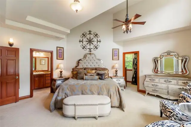 The main floor primary bedroom suite has vaulted ceilings giving it an expansive feel.