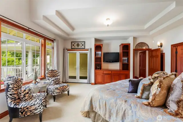 Primary bedroom with tray and vaulted ceiling. French doors lead to back deck and hot tub.
