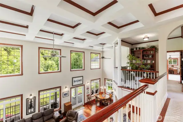 From the balcony looking over the great room and taking in the expansive windows and coffered ceilings.