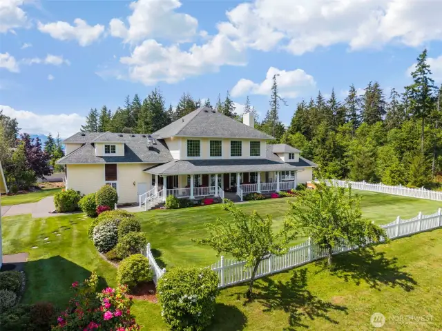 View of fenced in backyard and covered porches.