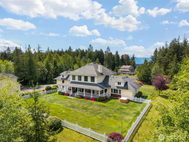 Partially fenced backyard  oasis with hot tub, expansive covered porches and outdoor kitchen designed for entertaining guests.