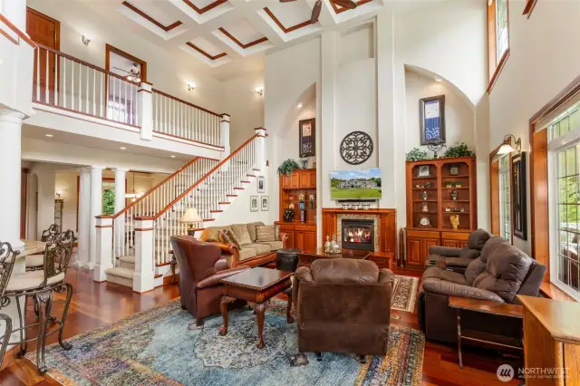 The great room enjoys loads of volume and custom coffered ceilings. Built in bookshelves and gas fireplace offer ambiance and sophistication to this room.