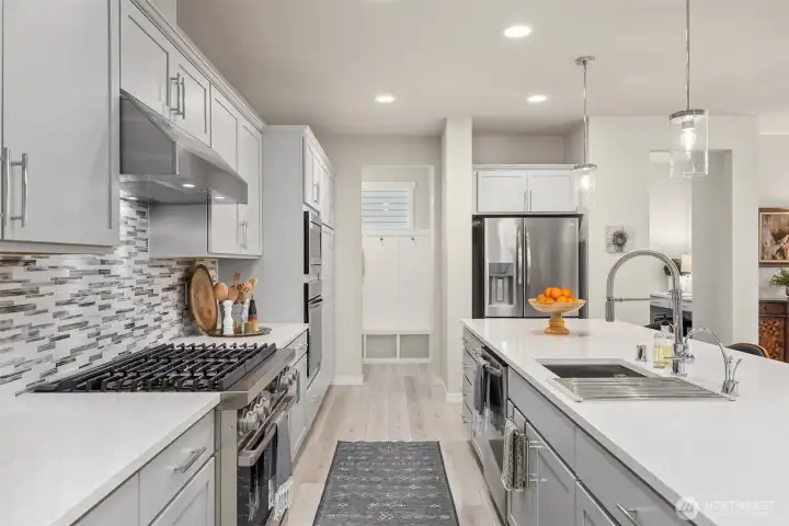 A useful mud room and walk in pantry frame the kitchen