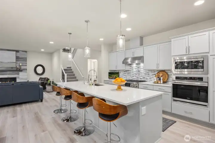 The expansive kitchen island offers ample storage making culinary efforts a breeze. Enjoy informal dining in the comfortable swivel stolols that convey with the home.