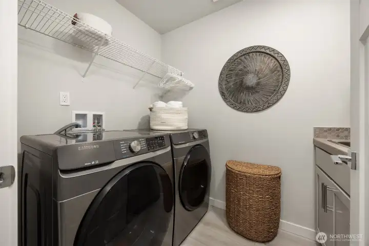 The 2nd floor laundry room is conveniently located next to the bedrooms and offers a vanity with a sink and storage.The high capacity HE Washer/Dryer convey with the home.