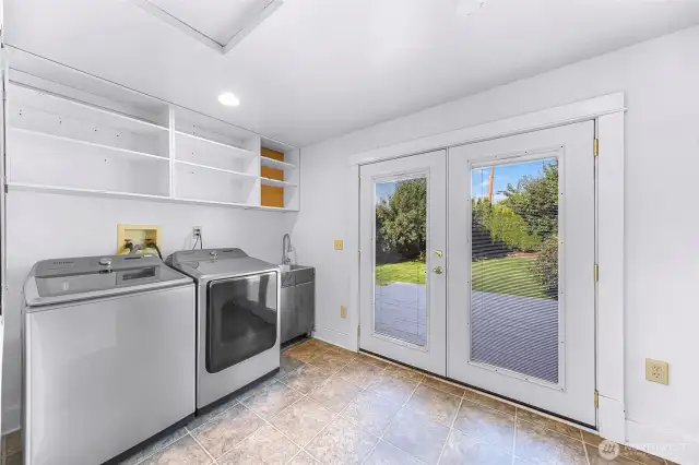 New washer and dryer in laundry room with lots of storage and French doors to back deck.