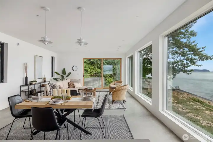 The open concept living and dining space has incredible wide open bay views throughout the day