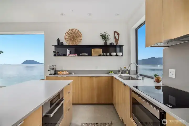 The kitchen features oak cabinetry and a custom metal open shelf as well as Caesarstone counters and a Fisher and Paykel fridge and Miele oven