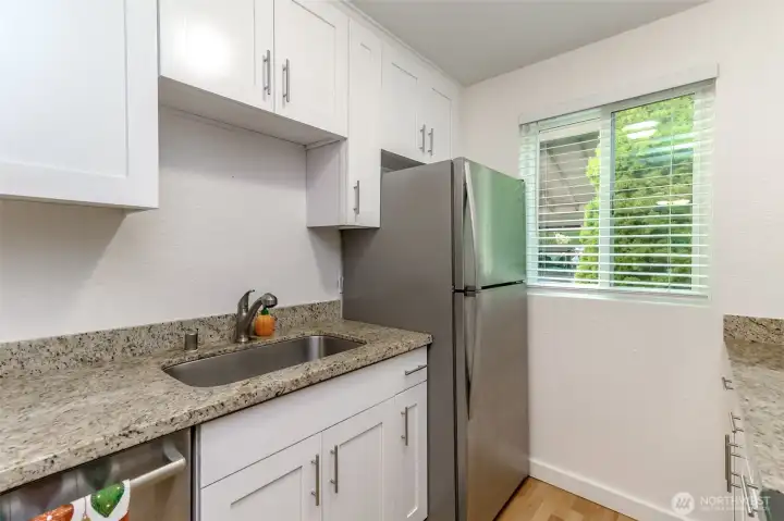 Recently updated kitchen with bright white cabinets and granite countertops.