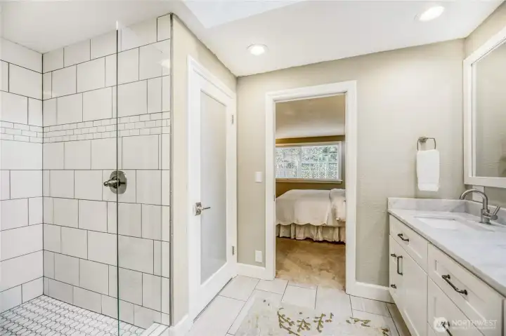Tiled shower in master. View of privacy door on toilet.