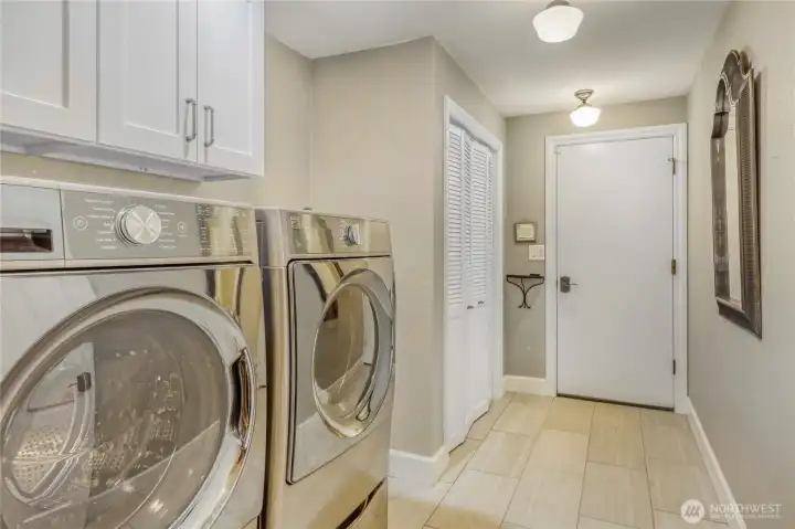 Laundry area leading to garage has tiled floor, cast iron washing sink and great storage.  Washer and dryer stay with home.