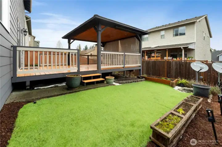 Well-maintained backyard with a raised deck and covered gazebo.