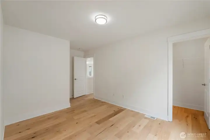 Two upper-level bedrooms, each featuring its own walk-in closet