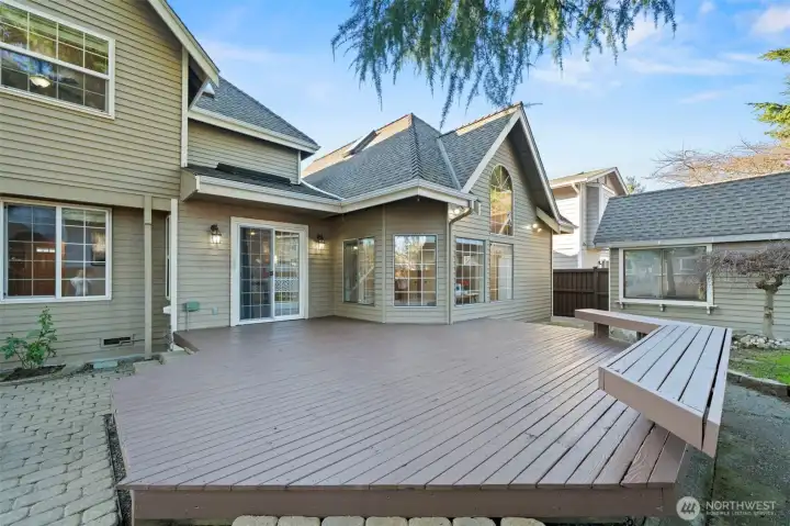 Elevated deck off the rear of the home with access to patio and yard.