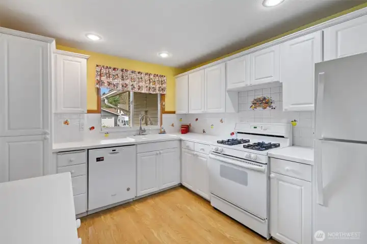 Kitchen with ample cabinetry, pantry and gas range.