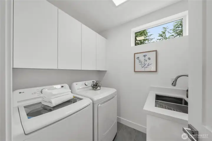 Well-appointed laundry room featuring a utility sink & abundant cabinetry