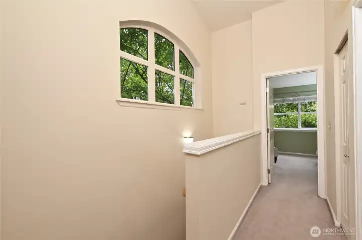 The hallway on the upper floor separates the primary bedroom from the second upper level bedroom and has a large linen closet, shown on the right.
