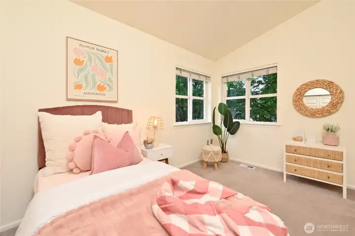 The second upper bedroom with vaulted ceilings could also be used as a home office. The maple trees bring nature inside and offer summer shade.