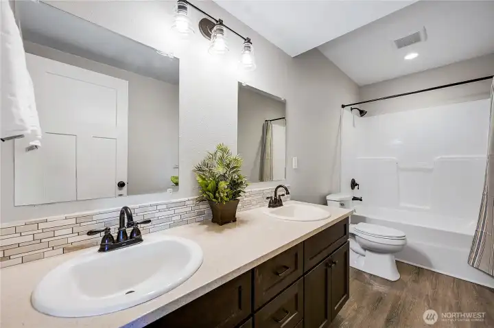 The spotless lower level full bath, with double sinks.