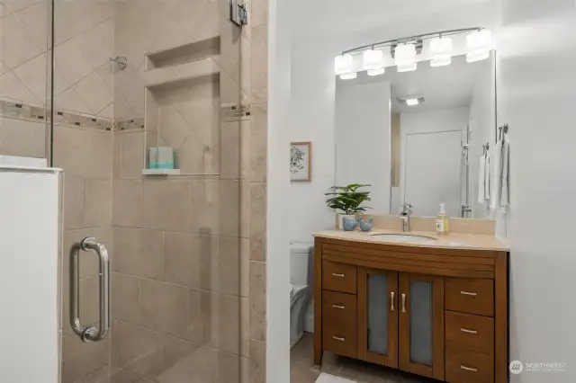 Nicely appointed 3/4 bath with custom glass shower doors.