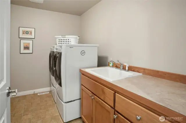 Spacious laundry room with built-in cabinets and sink.