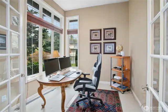 French doors lead to main level den/office.  There are also five bedrooms including the primary suite on the upper level.