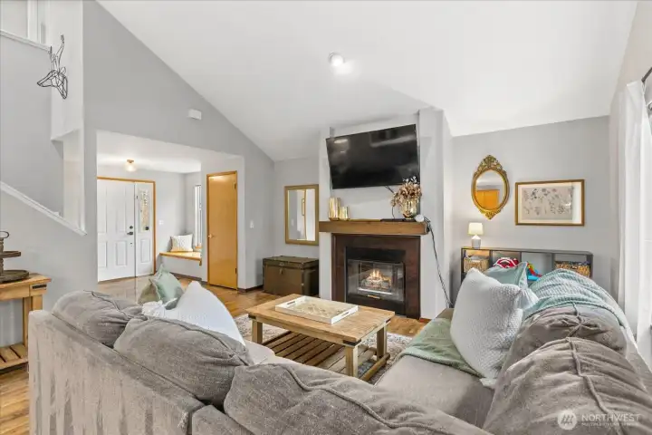Open concept living on the lower level with laminate floors throughout and a cozy gas fireplace in the living room.