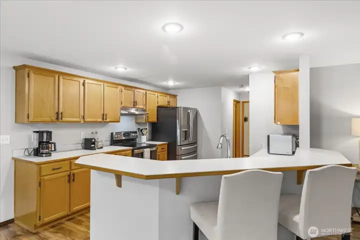 The kitchen offers a high bar with room for 4 chairs, stainless appliances and pantry space.
