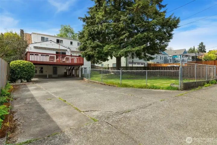 Alley access to wide driveway and fenced back yard