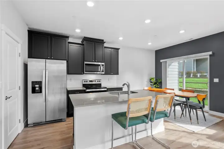 Light-filled kitchen featuring quartz countertops and stainless steel appliances.