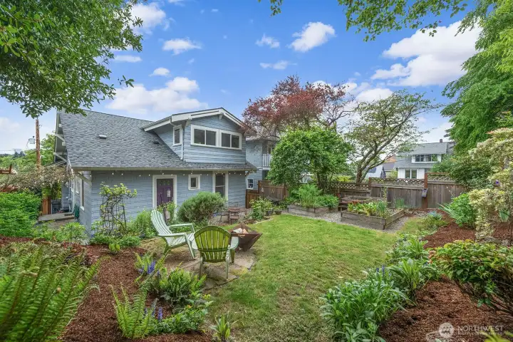 Rear yard has mature landscaping and herb boxes.