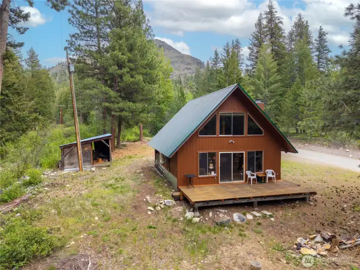 Charming A-frame cabin with classic mountain character, metal roof, and warm natural exterior tones nestled among towering pines.