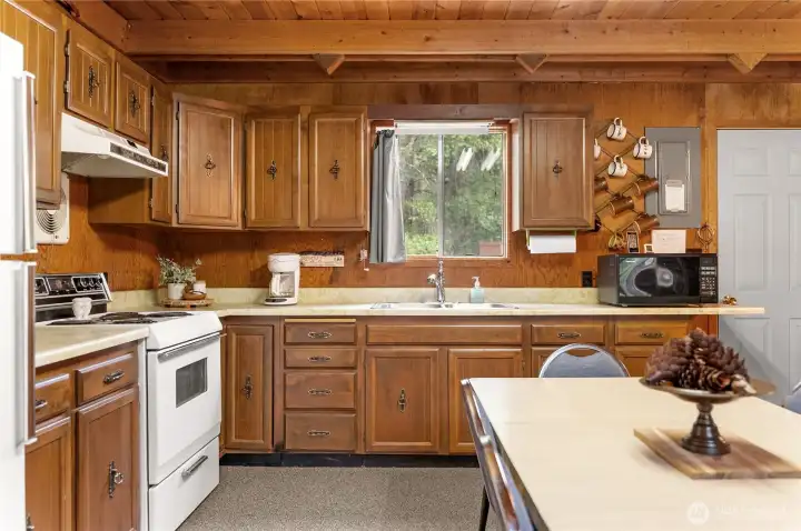 Warm and inviting kitchen with abundant cabinetry, generous counter space, and large dining area perfect for gathering after a day of recreation in the Methow Valley.