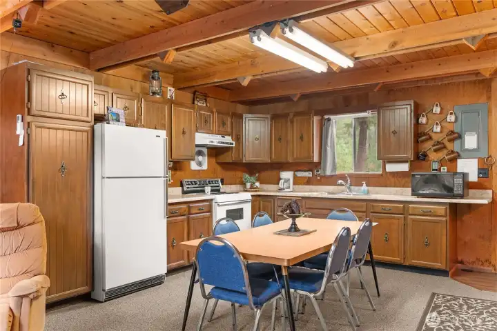 Cabin-inspired kitchen and dining space offering rustic warmth, exposed timber accents, and room to host family and friends year-round.