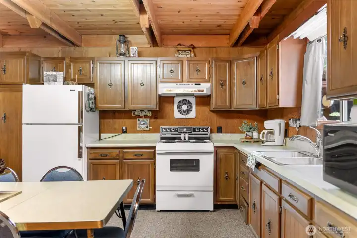 Functional U-shaped kitchen with ample storage, easy workflow, and vintage cabin character complemented by warm wood finishes.