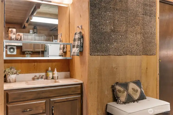 Convenient main-level bathroom with vanity, rustic wood accents, and plenty of natural cabin charm.