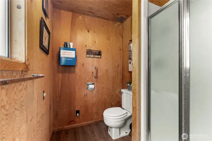 Rustic cabin bathroom featuring warm wood finishes, walk-in shower, and charming mountain retreat character throughout