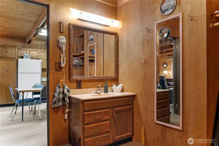 Multi-purpose bonus space featuring built-in hanging storage, vanity sink, and mirror area ideal for guests or overflow sleeping accommodations.