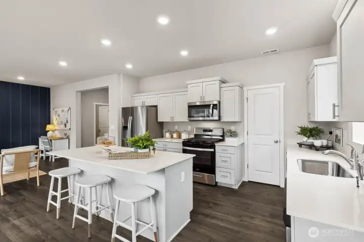 Large kitchen with huge walk-in pantry and big island with breakfast bar. Actual home is under construction. Colors, materials, and features may vary. See site agent for details. Large kitchen with huge walk-in pantry and big island with breakfast bar. Actual home is under construction. Colors, materials, and features may vary. See site agent for details.