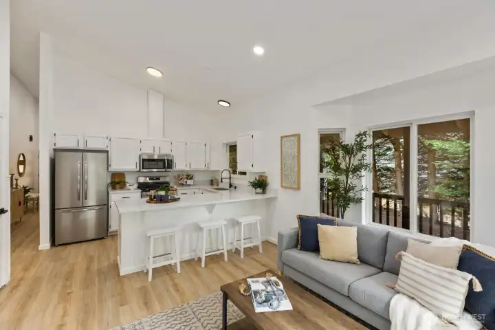 Wood flooring and an oversized island create a warm, open flow between kitchen and living areas. Wood flooring and an oversized island create a warm, open flow between kitchen and living areas.