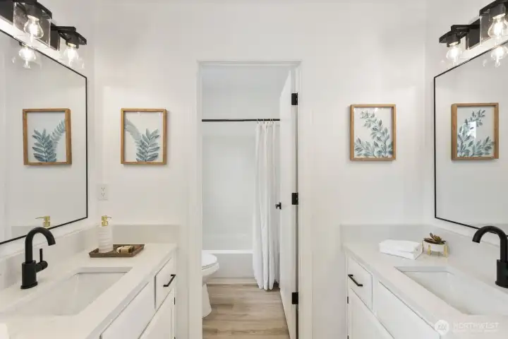 A spa-like bath featuring a dual-sink vanity, framed mirrors, and elegant sconce lighting. A spa-like bath featuring a dual-sink vanity, framed mirrors, and elegant sconce lighting.