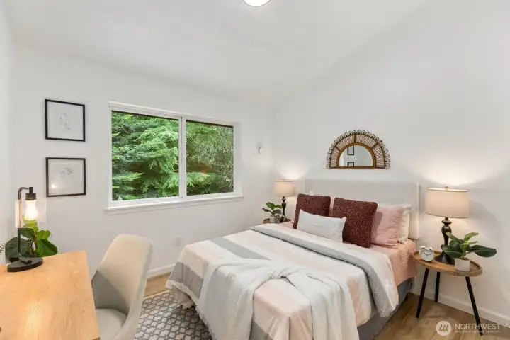 A tranquil space with a window view of surrounding greenery and a curated gallery wall. A tranquil space with a window view of surrounding greenery and a curated gallery wall.