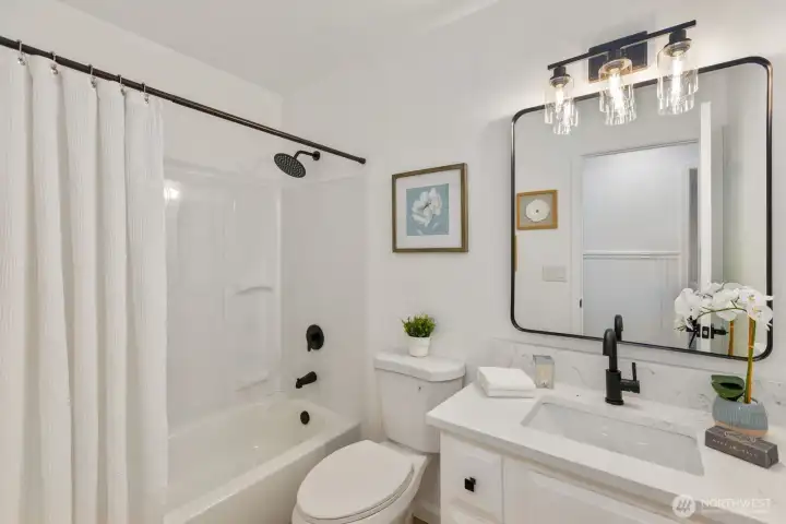 A well-appointed bath with a tub/shower combo and contemporary black fixtures. A well-appointed bath with a tub/shower combo and contemporary black fixtures.