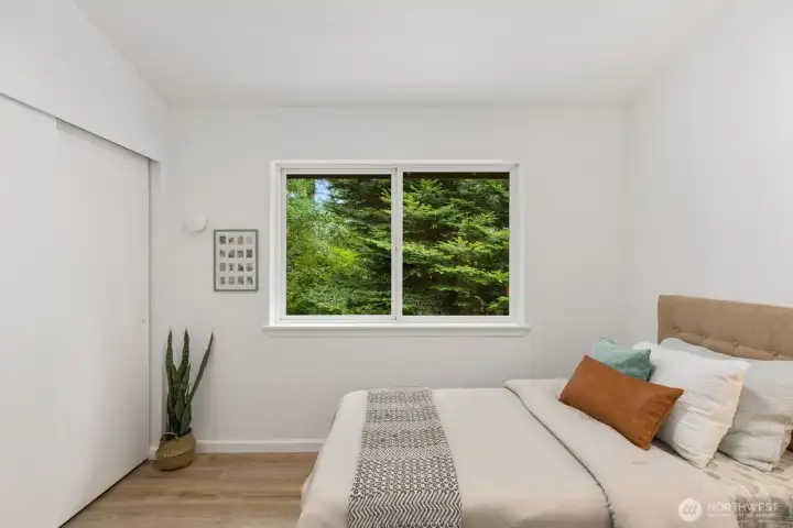 A comfortable retreat with wood-look flooring and a peaceful outdoor view. A comfortable retreat with wood-look flooring and a peaceful outdoor view.