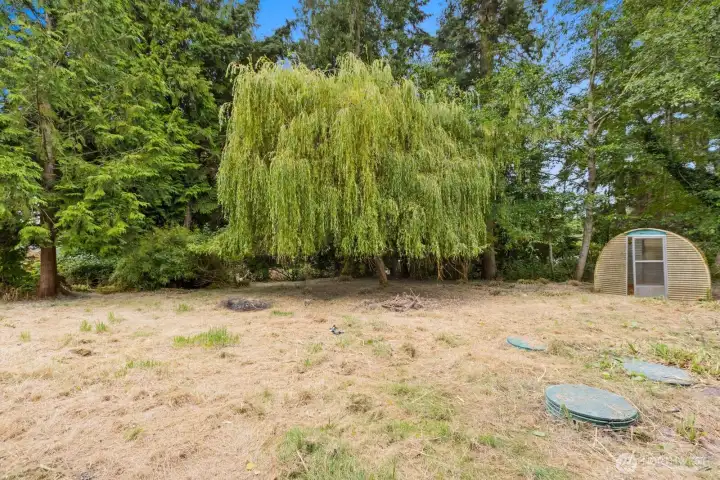 Open lawn space bordered by mature trees offers room to garden, play, or simply relax outdoors. Open lawn space bordered by mature trees offers room to garden, play, or simply relax outdoors.