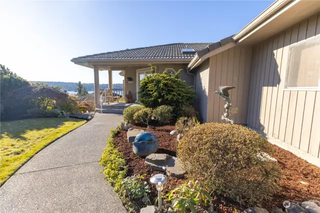 Beautifully landscaped yard with a full sprinkler system and washed aggregate walkways, patio, and driveway